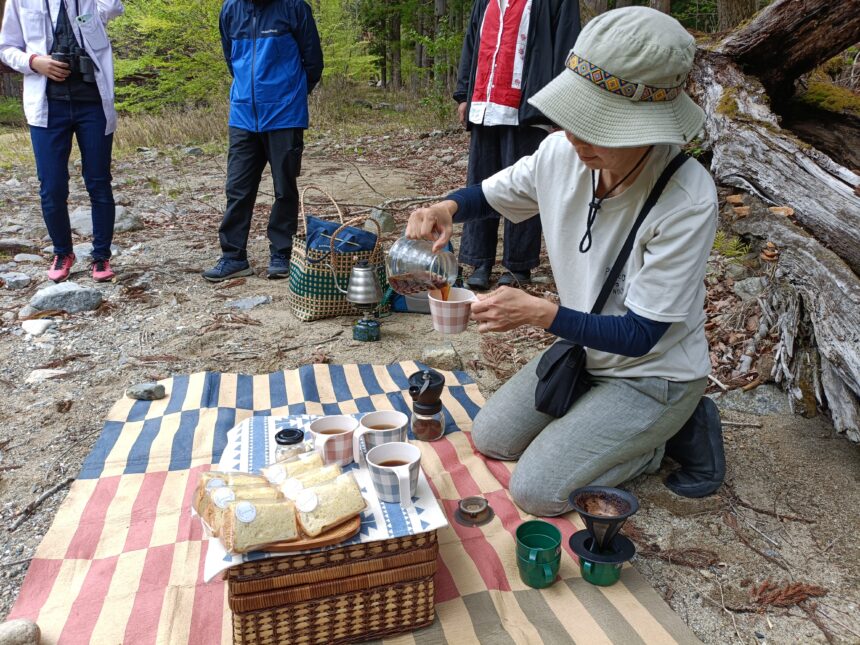 野鳥ウォッチングCAFEツアーでのティータイム風景。レジャーシートの上で、タイヨーコーヒーの焙煎豆でコーヒーをドリップしている様子と、atatakaのシフォンケーキ。